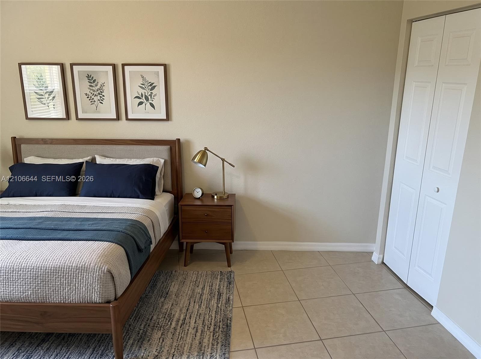 Neutral-toned walls paired with large-format tile flooring and white paneled bi-fold closet doors