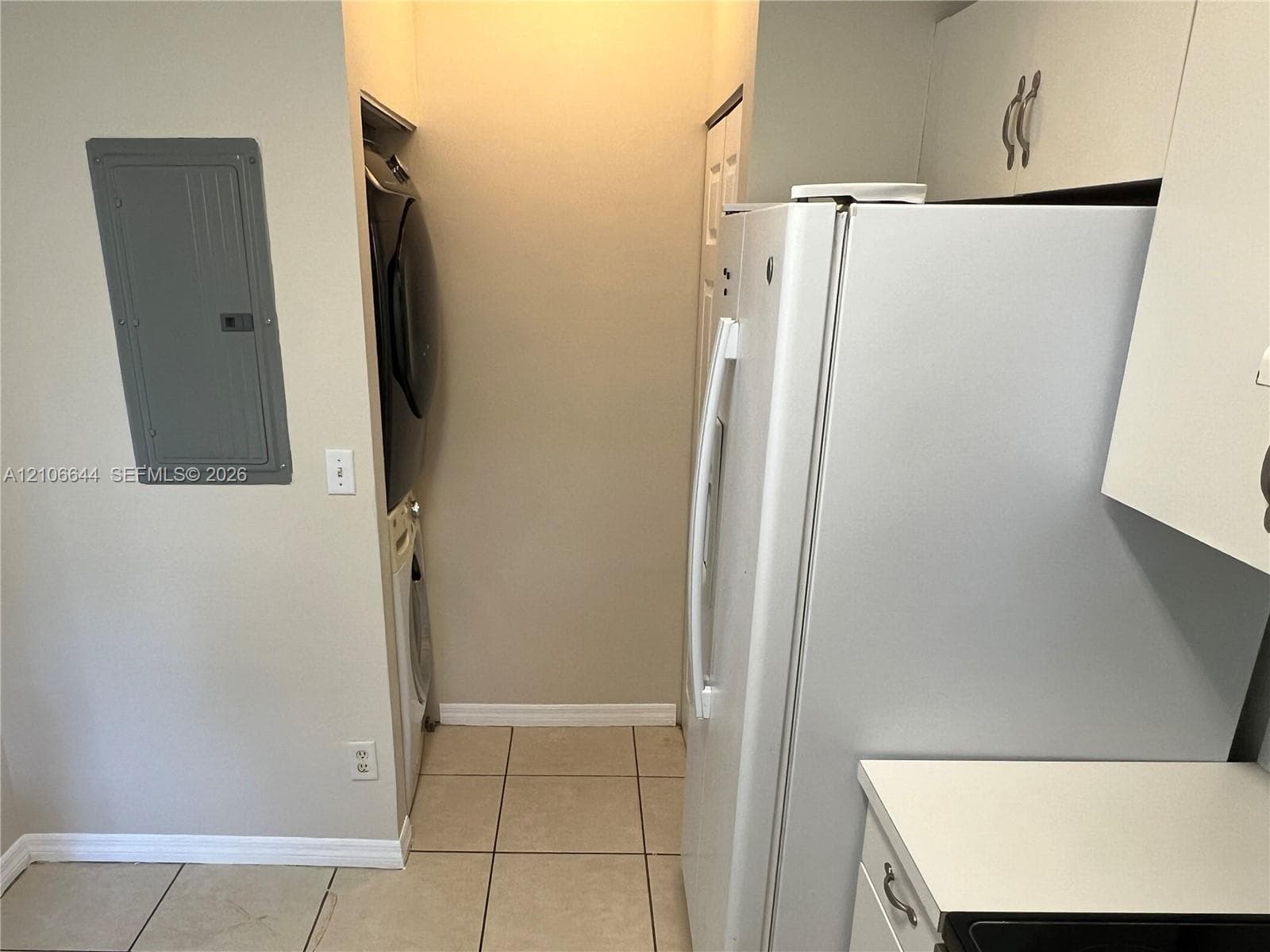 Utility area featuring tile flooring, white cabinetry, and built-in laundry hookups