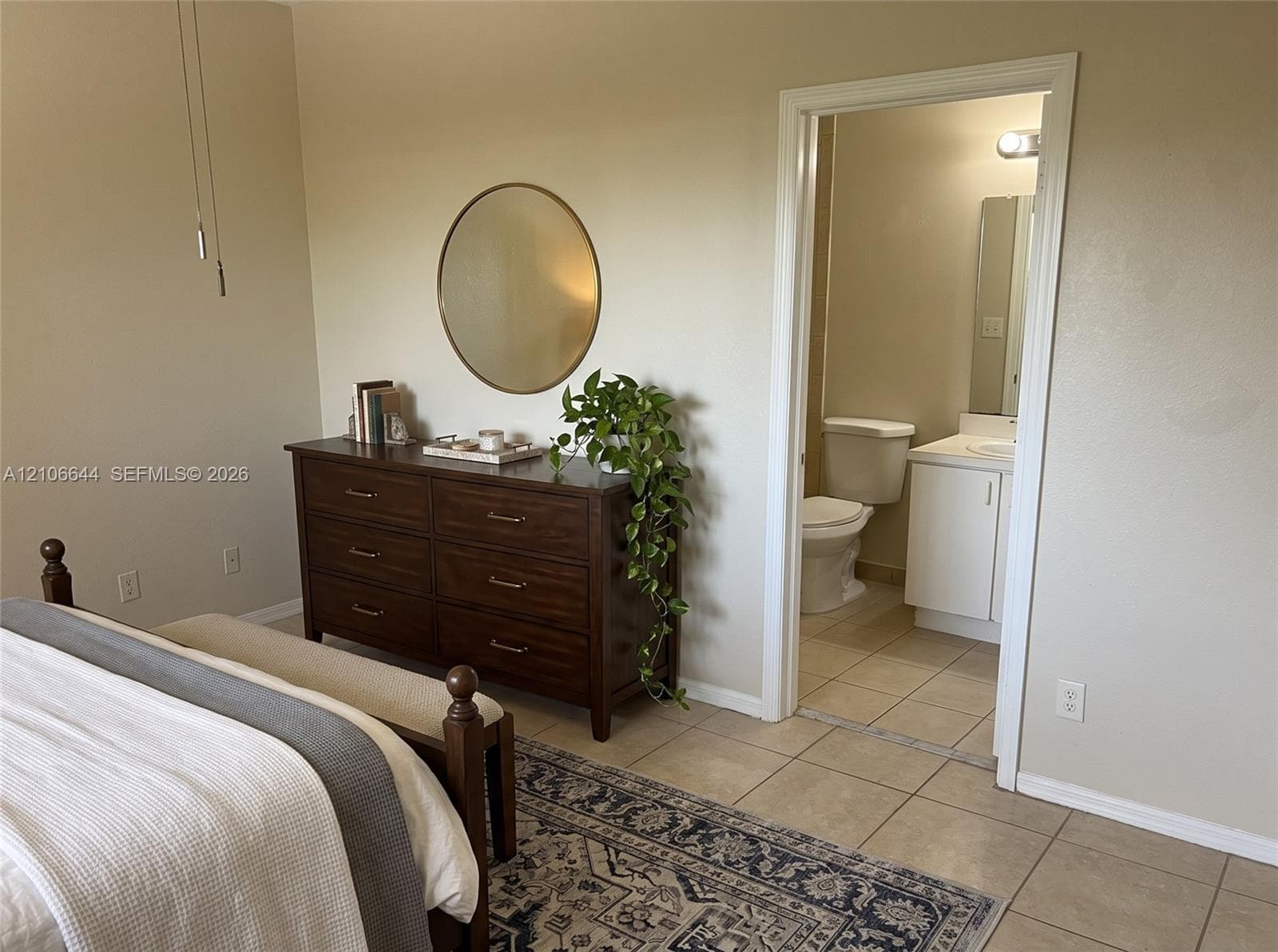 Neutral wall tones, ceramic tile flooring, and a vanity cabinet with a integrated sink