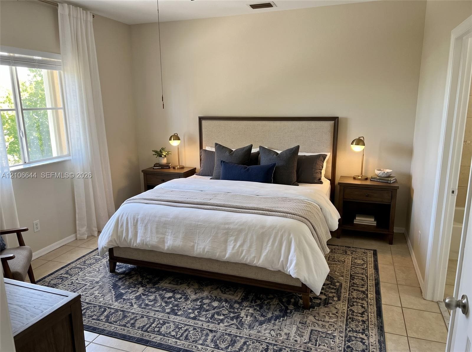 Neutral-toned walls, tile flooring, and a multi-pane window with natural lighting