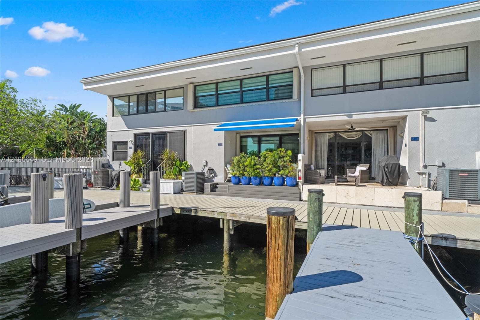 Waterfront boardwalk featuring a private boat slip, concrete bulkhead, and industrial-grade pilings