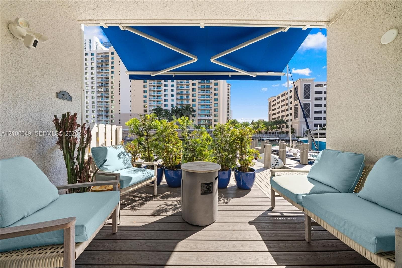 Waterfront terrace featuring composite decking, an retractable fabric awning, and direct access to a private boat dock