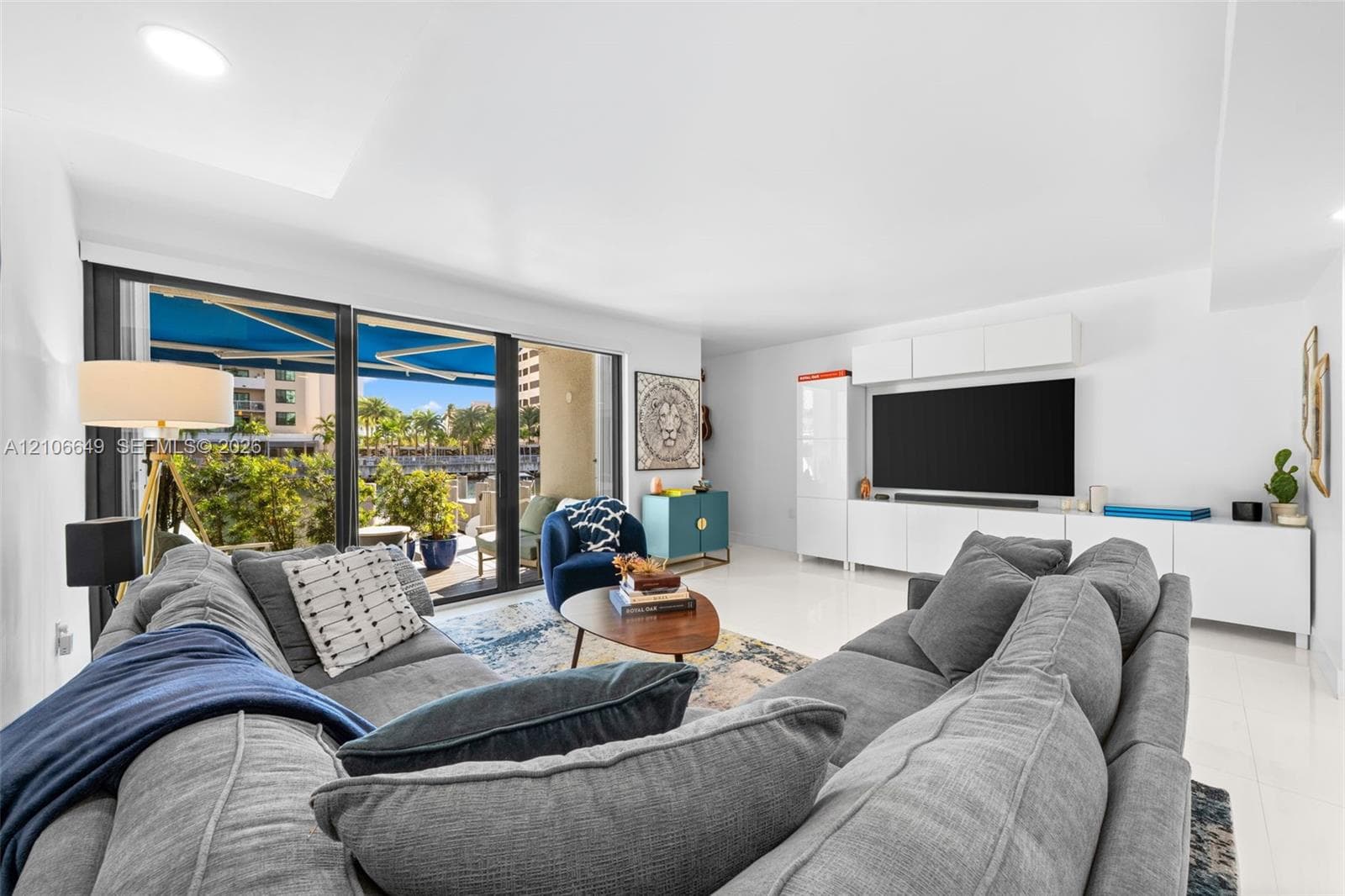 Hallway featuring polished tile flooring, recessed lighting, and a bathroom equipped with a floating vanity, light-toned wood-finish cabinetry, and a stone-tiled accent wall