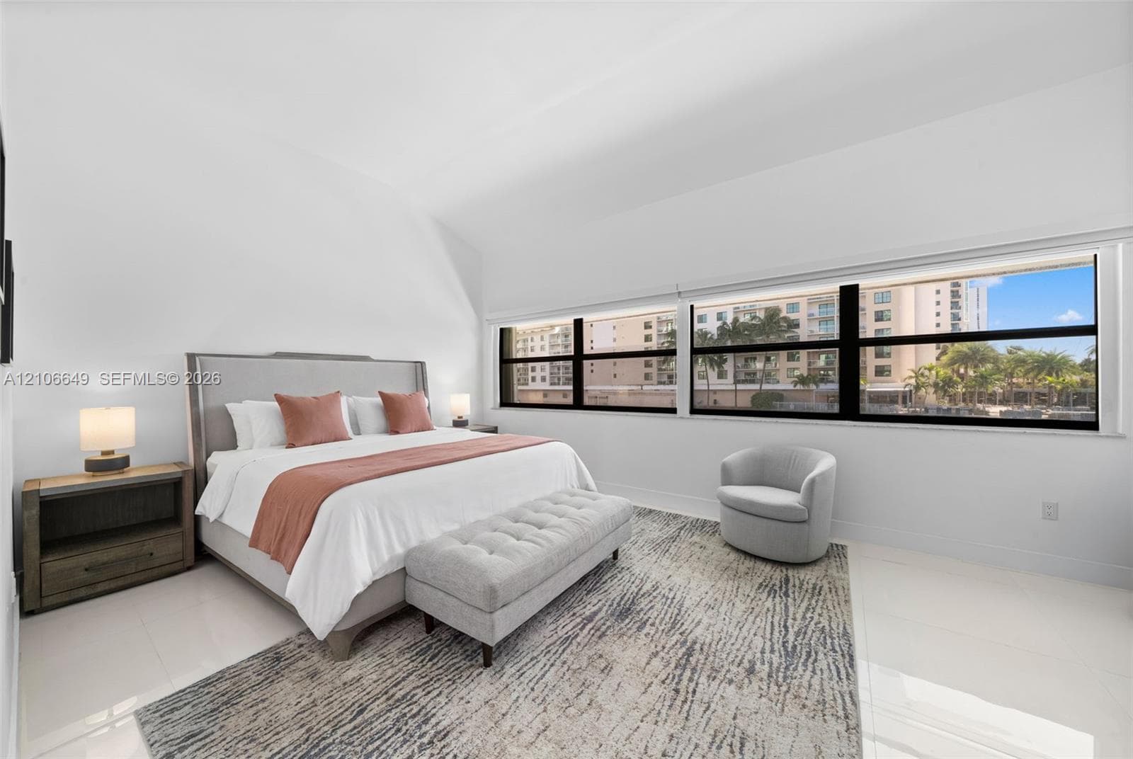 Spacious interior with high vaulted ceilings, large expansive window configuration, and polished tile flooring