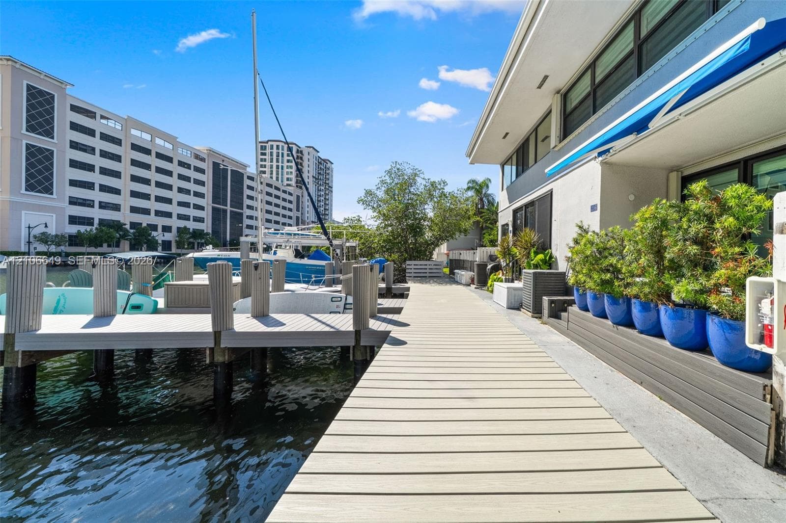 Waterfront property featuring a private deep-water dock, integrated boat slips, paved pathways, and tennis courts