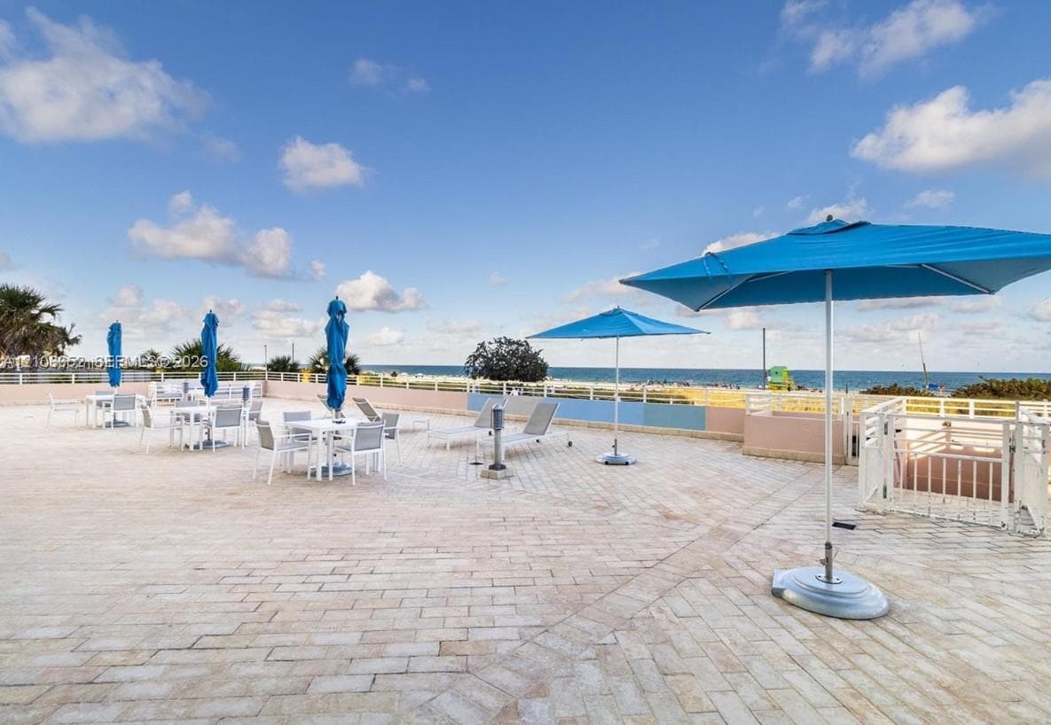 Expansive outdoor terrace featuring stone-paver flooring and white metal perimeter railings