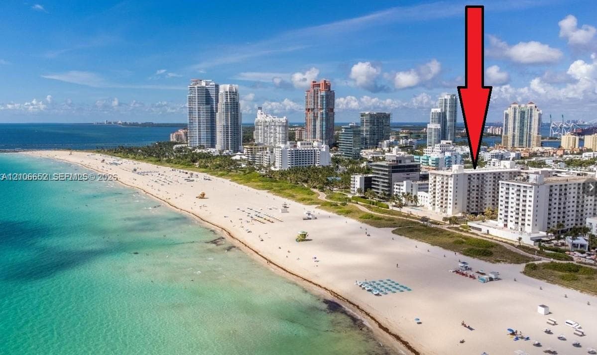 Aerial perspective of oceanfront high-rise structure featuring proximity to sandy coastline SOUTH OF FIFTH