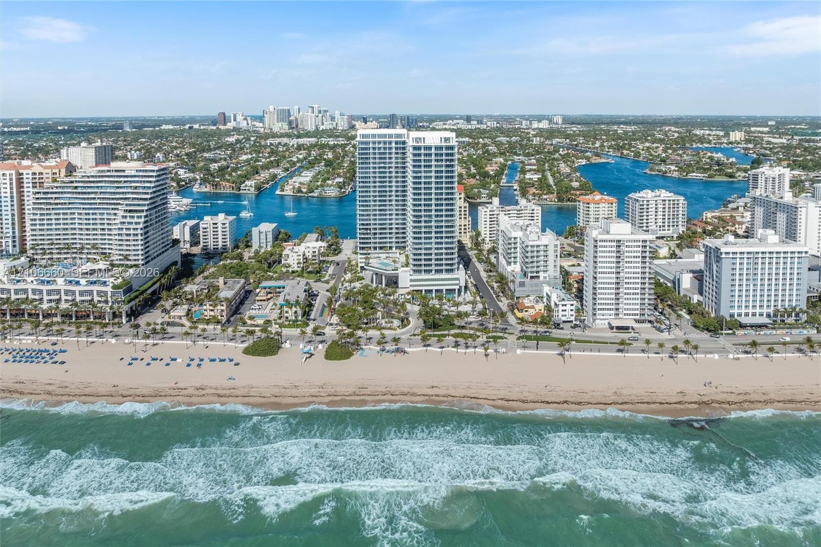 Aerial perspective of a coastal high-rise property featuring direct beach access, proximity to the Atlantic Ocean, and established waterfront surroundings