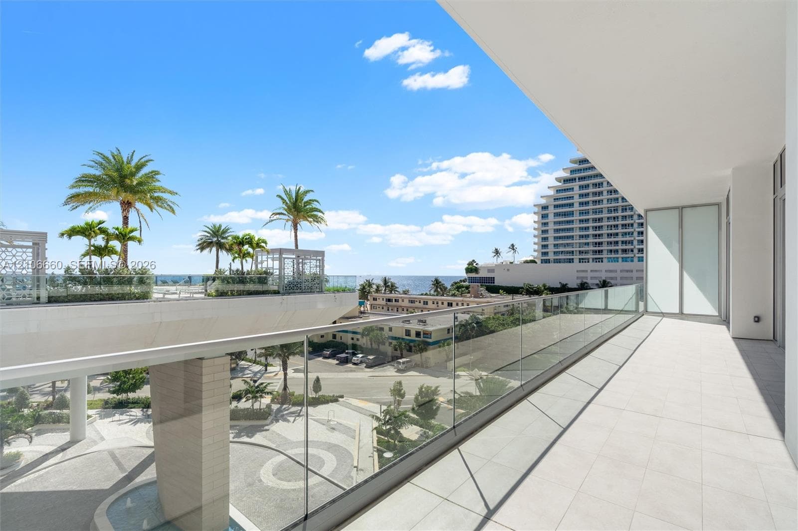 Covered terrace with large-format tile flooring and a sleek glass panel railing