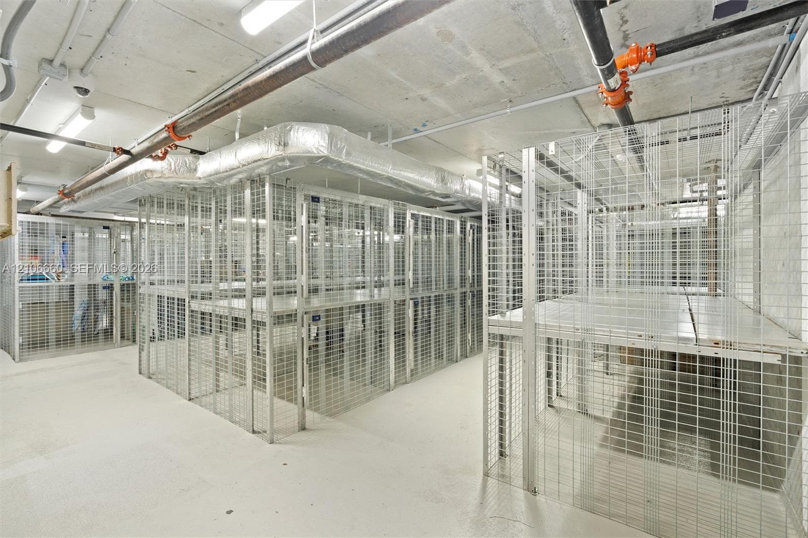 Secure, dedicated wire-mesh storage units with integrated elevated shelving and concrete flooring