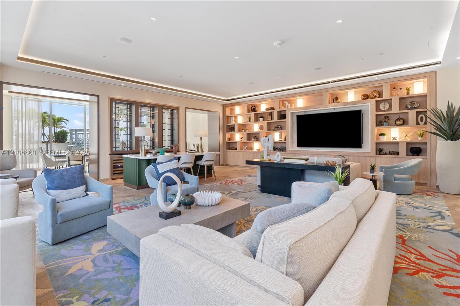Open-concept room featuring integrated cove lighting, floor-to-ceiling custom wood-finish built-in shelving, wood-finish flooring, and a wine storage unit with a metal-frame glass enclosure