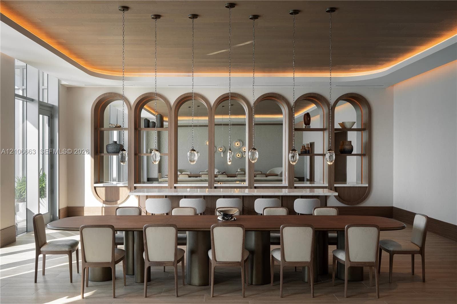Custom built-in arched shelving with integrated lighting, wood-paneled tray ceiling, stone-top bar counter, and suspended glass pendant lighting