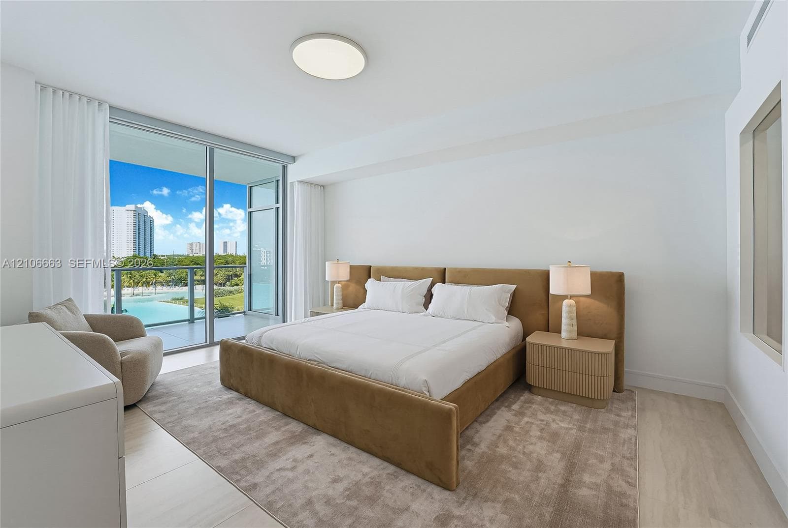 Floor-to-ceiling glass sliding doors, private balcony, recessed ceiling lighting, and neutral light-tone flooring