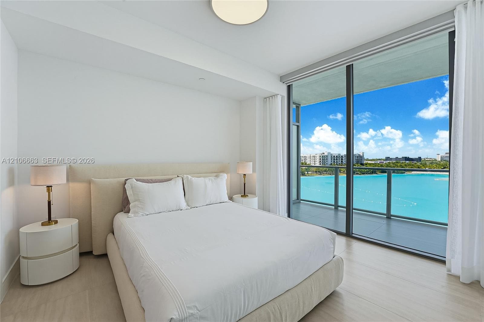 Floor-to-ceiling sliding glass doors, private covered balcony, wood-finish flooring, and neutral wall tones