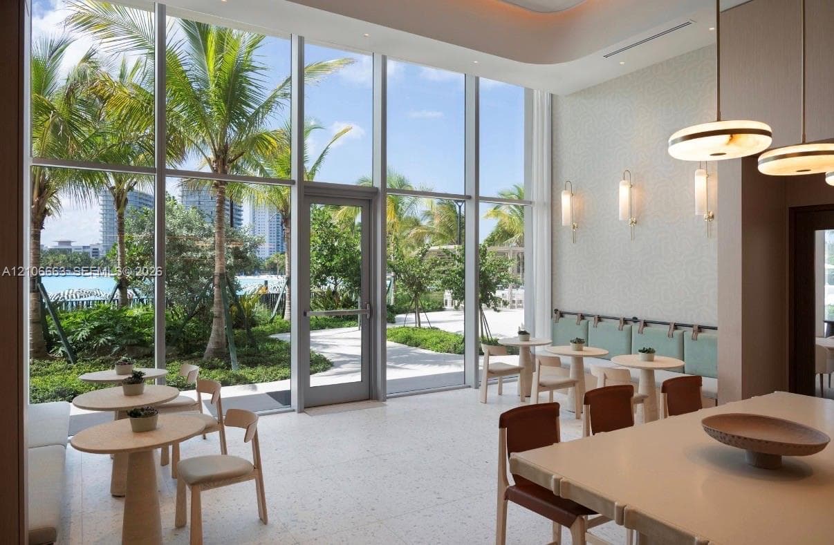 Floor-to-ceiling windows, light-toned terrazzo flooring, recessed lighting, and modern wall-mounted light fixtures
