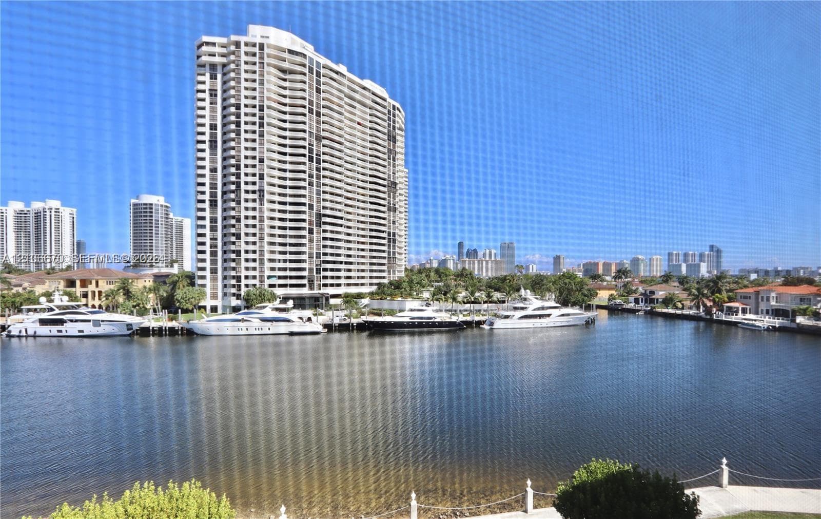 Waterfront setting featuring a concrete bulkhead, deep-water canal, and anchored recreational vessels