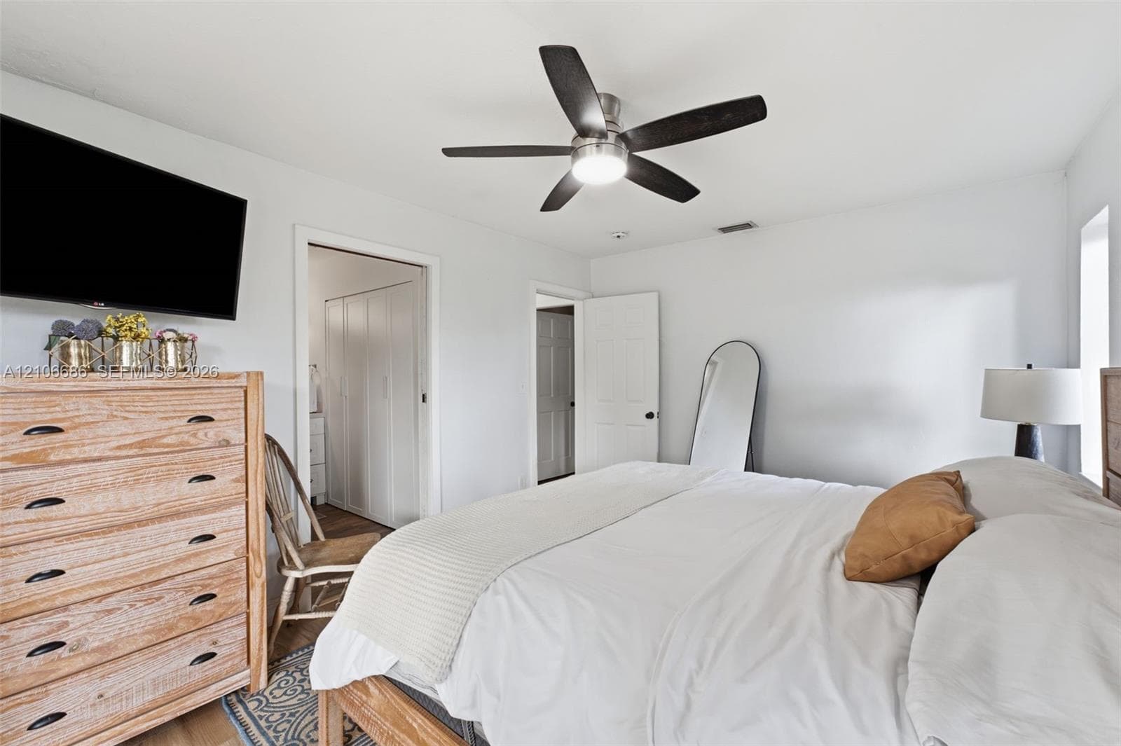 Neutral-toned room featuring a five-blade ceiling fan with integrated lighting and multi-panel interior doors