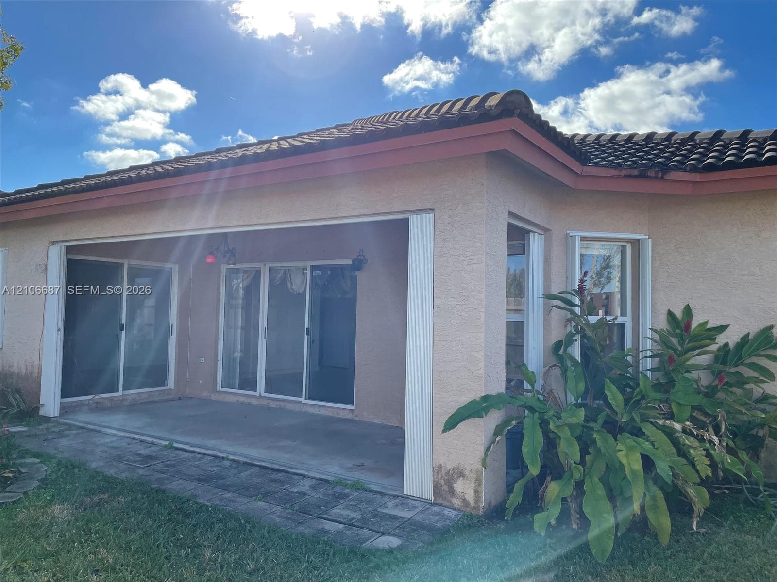Covered concrete patio featuring sliding glass doors and a concrete tile roof