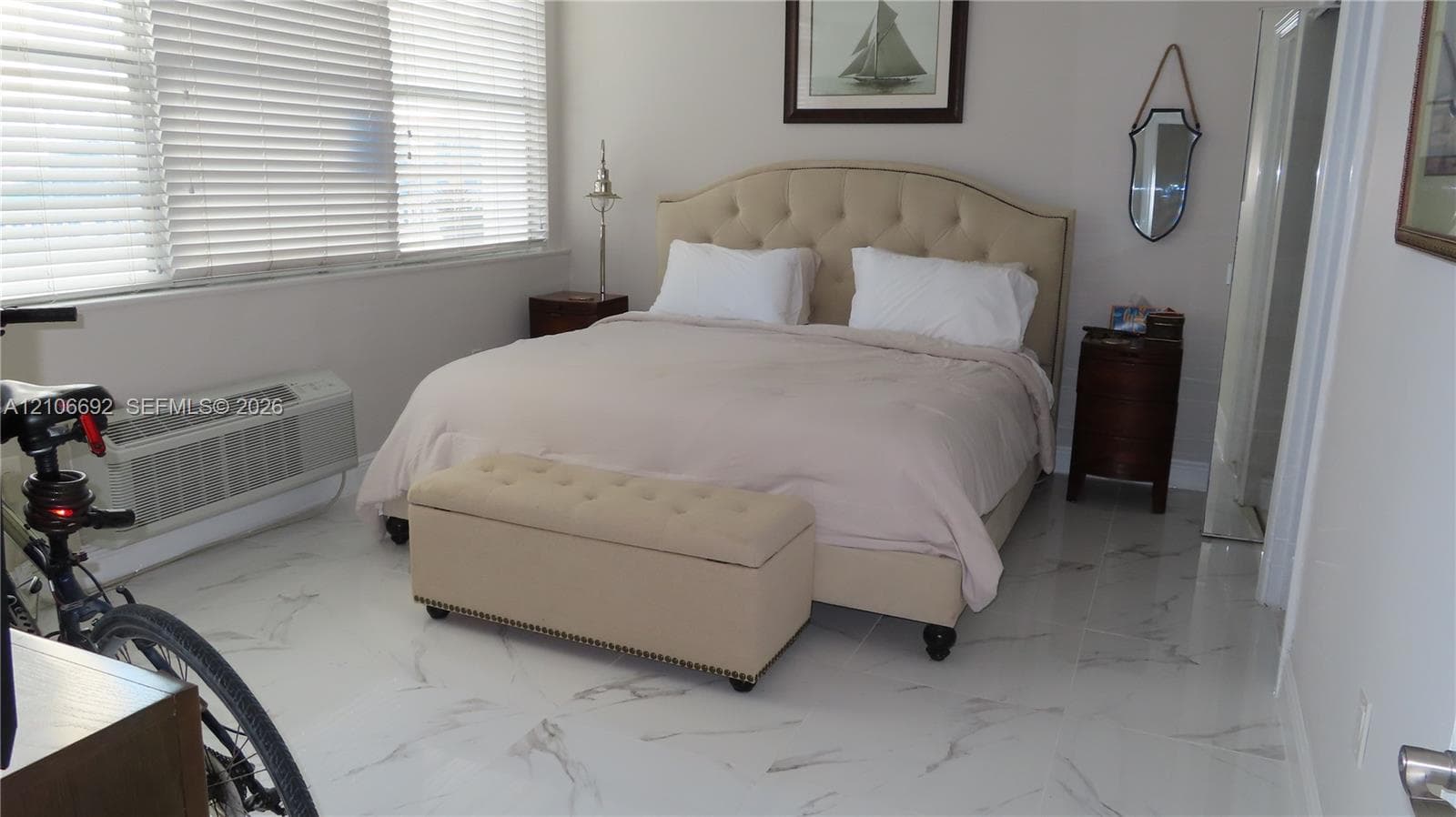 Large-format polished tile flooring featuring a veined stone pattern and expansive window banks with integrated horizontal blinds
