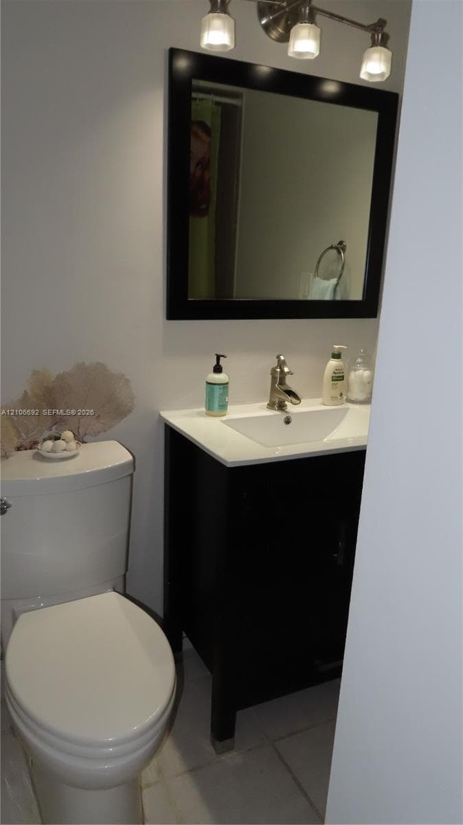 Dark-finish vanity with a rectangular sink, stone-composite countertop, matching framed mirror, and brushed-nickel faucet fixture