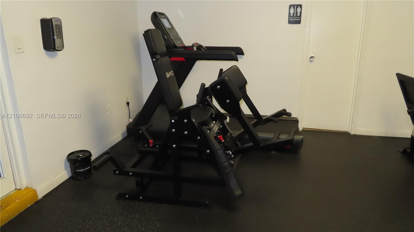 Fitness center featuring black resilient rubber flooring and interior doorway access