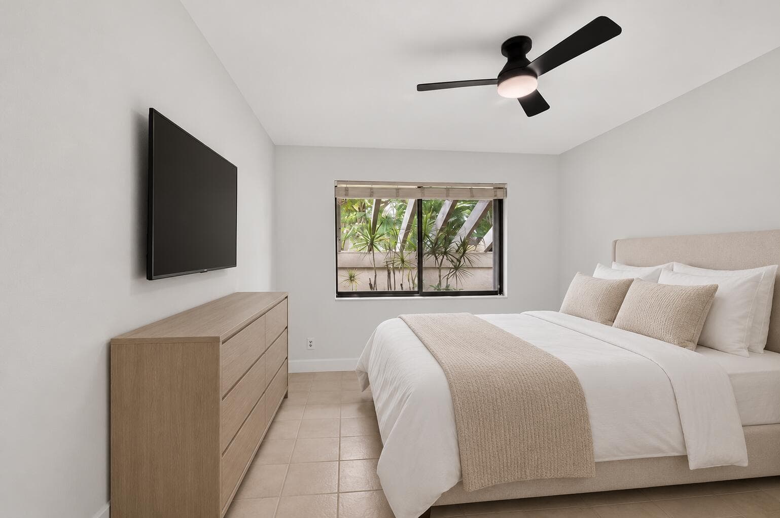 Calm guest bedroom with wall-mounted TV