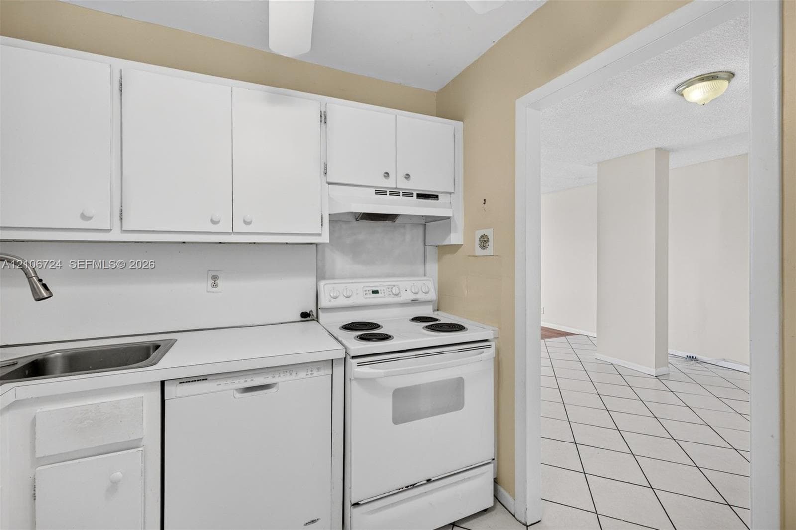 Kitchen featuring white cabinetry, solid-surface countertops, integrated stainless steel sink with gooseneck faucet, white electric range, and dishwasher