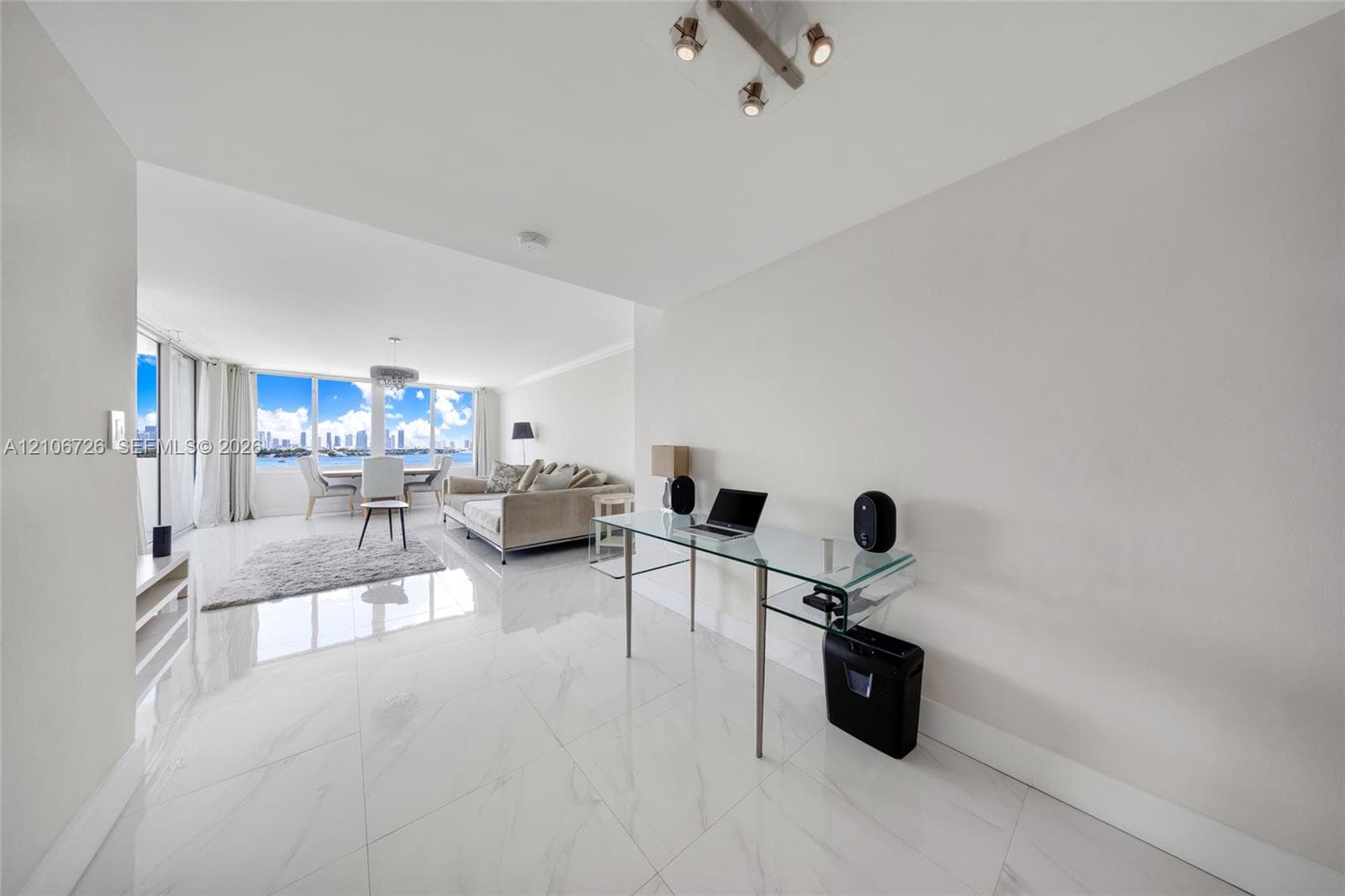 Large-format stone-style tile flooring, floor-to-ceiling windows, and multi-directional overhead track lighting