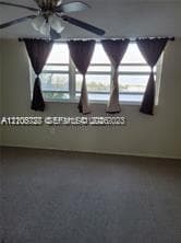 Multi-panel window configuration featuring horizontal sliding panes, centered ceiling fan with integrated multi-bulb light fixture, and neutral wall tones