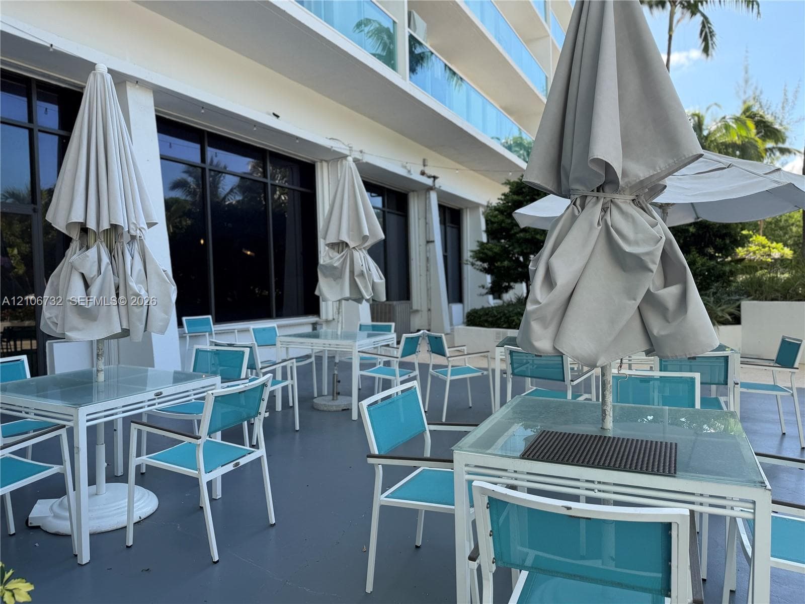 Covered outdoor terrace featuring glass-paneled walls, tinted floor-to-ceiling windows, and hard-surface flooring