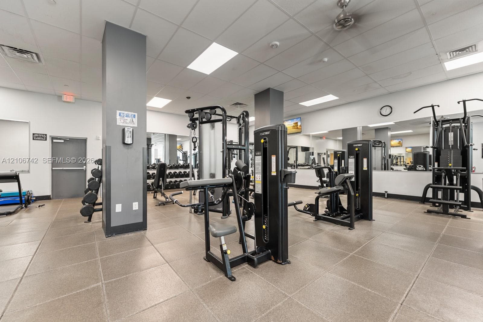 Fitness center featuring large-format tile flooring, mirrored walls, recessed lighting, and a ceiling-mounted fan