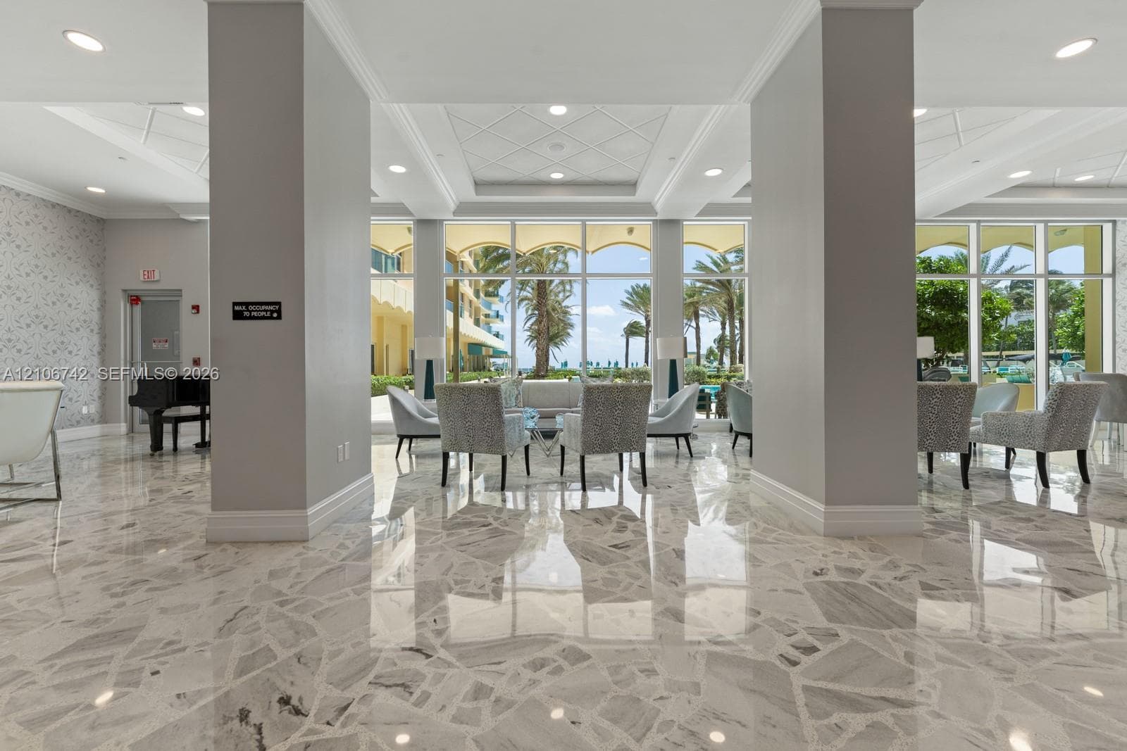 Polished stone flooring, floor-to-ceiling windows, recessed lighting, and a coffered ceiling with patterned detailing