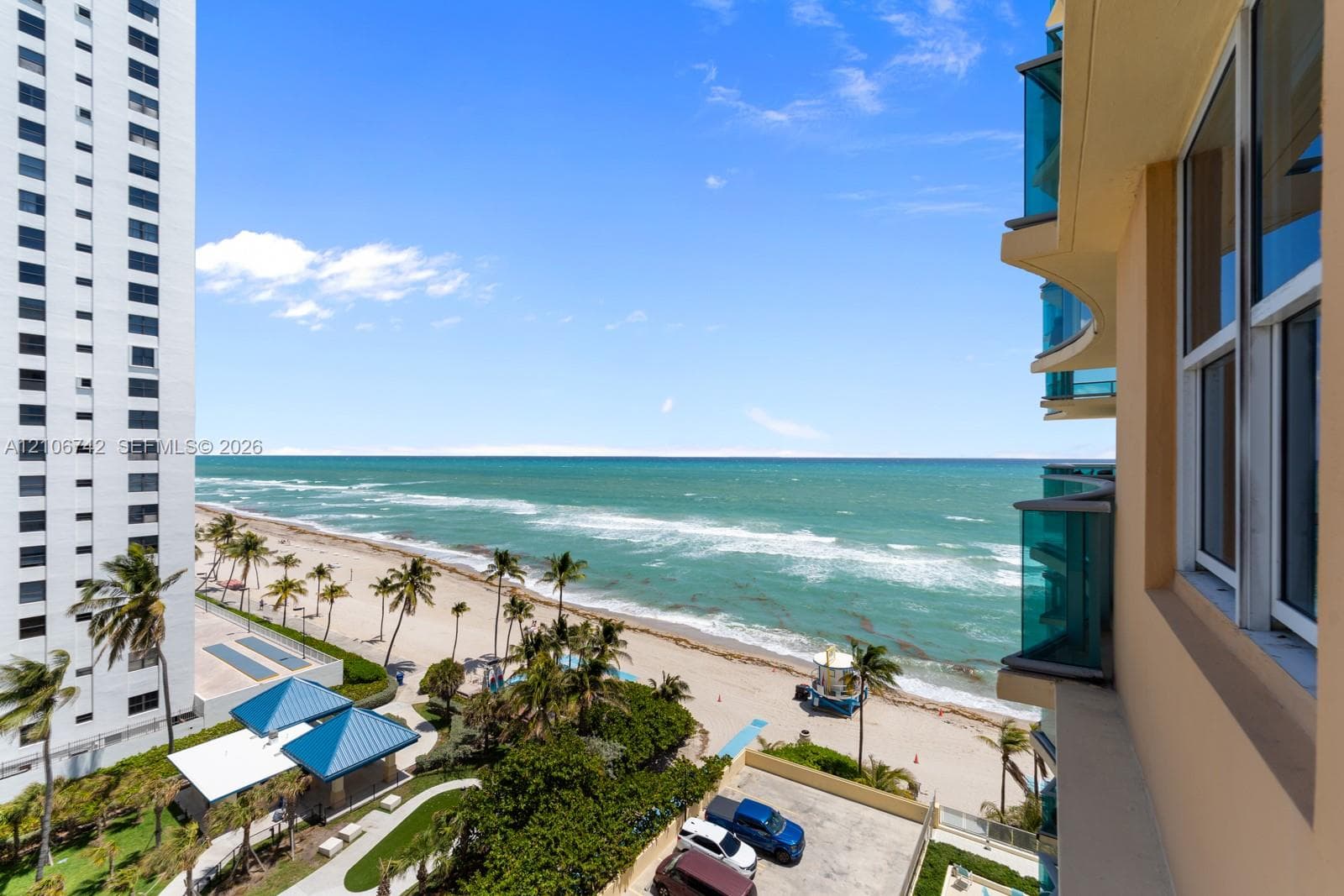 Elevated balcony featuring glass-panel railings and direct ocean frontage