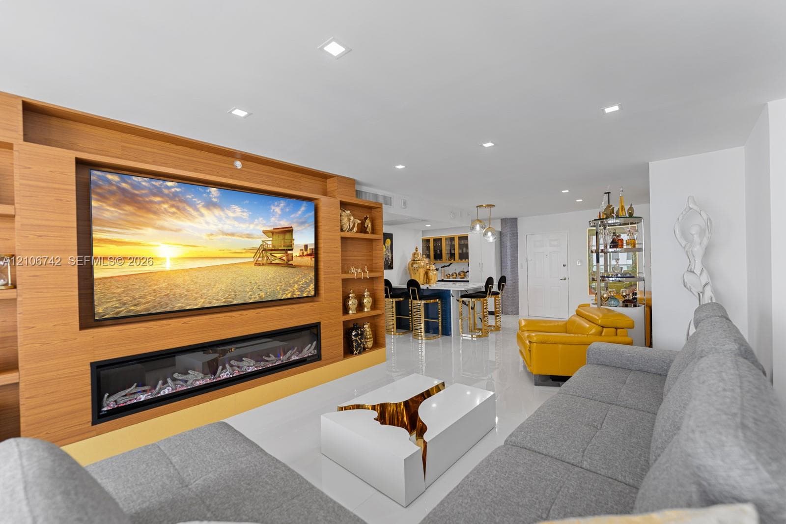 Custom wood-finish built-in shelving, integrated linear electric fireplace, recessed ceiling lighting, and polished stone-finish flooring