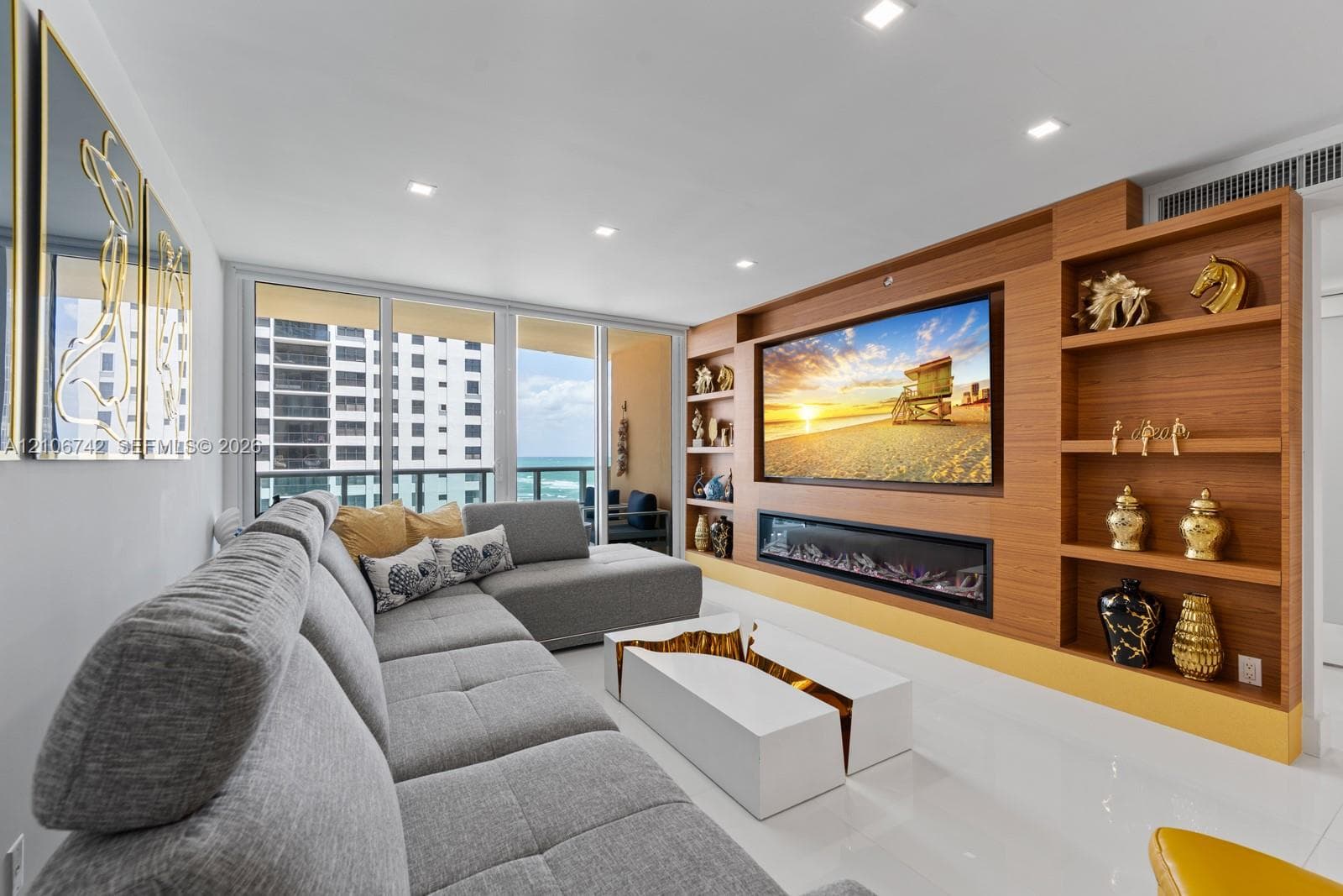 Floor-to-ceiling glass paneling, built-in wood-finish cabinetry, recessed ceiling lighting, and a horizontal integrated electric fireplace