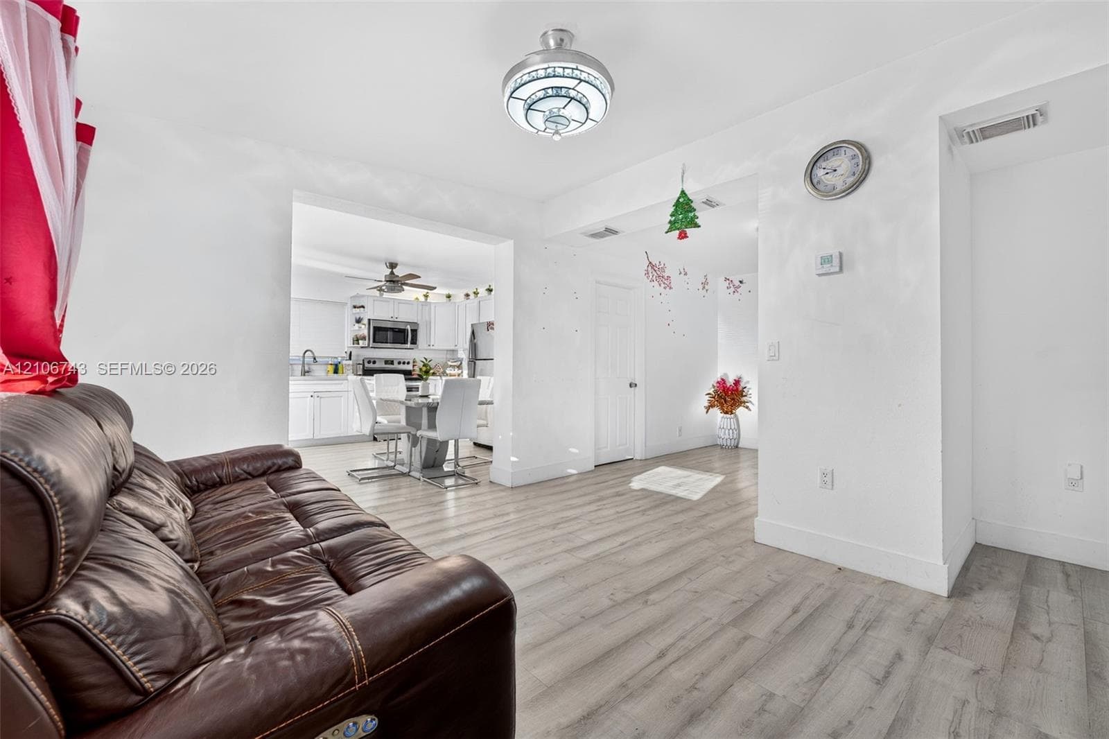 Wood-finish flooring, flush-mount decorative ceiling light fixture, and white cabinetry