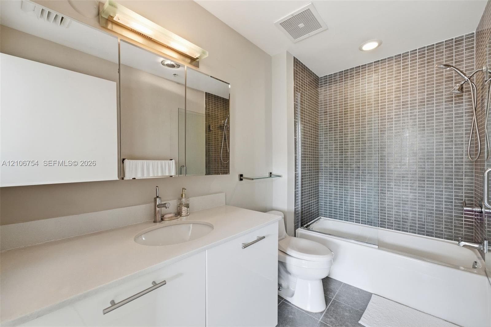 Full bathroom featuring a white vanity