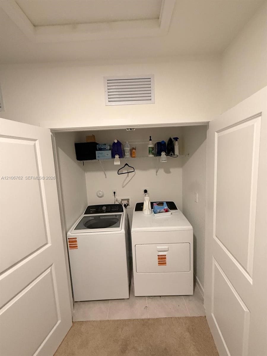 Laundry closet featuring dual paneled doors and an overhead wire shelving unit