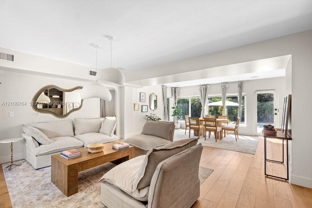 Open-concept living space featuring wood-finish flooring, recessed lighting, and large windows with outdoor access