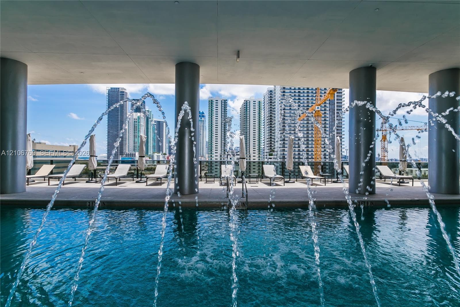 Swimming pool featuring water fountains, concrete columns, and a paved deck