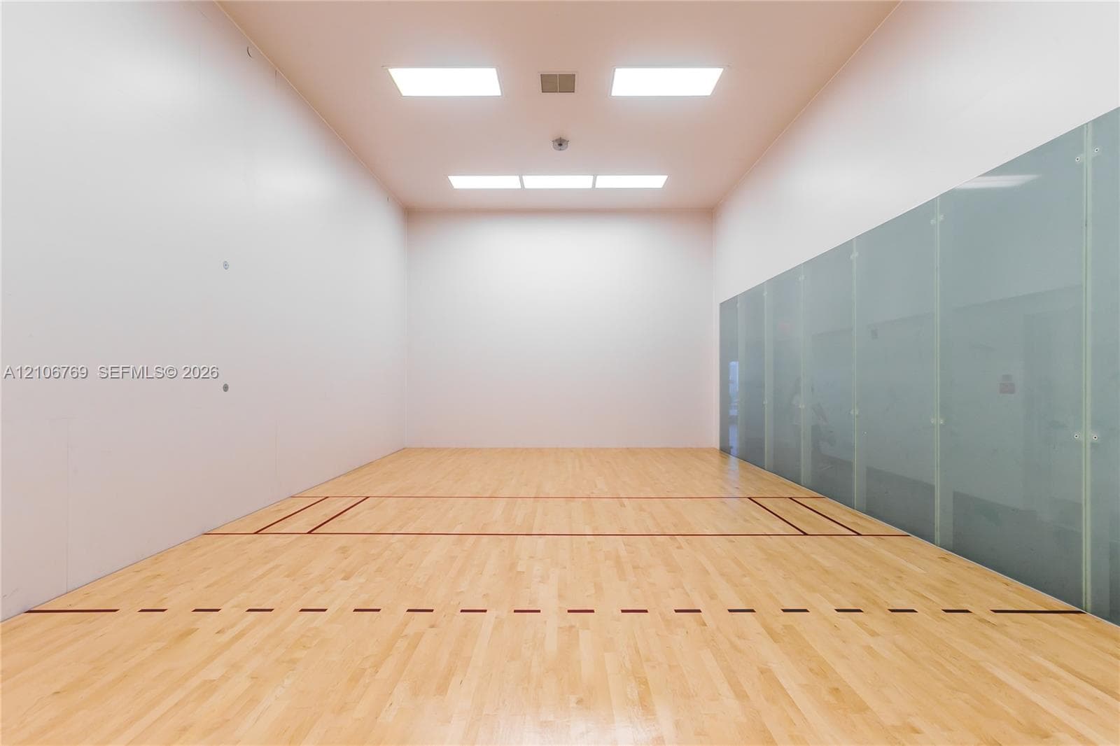 Recreation court featuring wood-finish flooring, high ceilings, recessed lighting, and a glass wall panel
