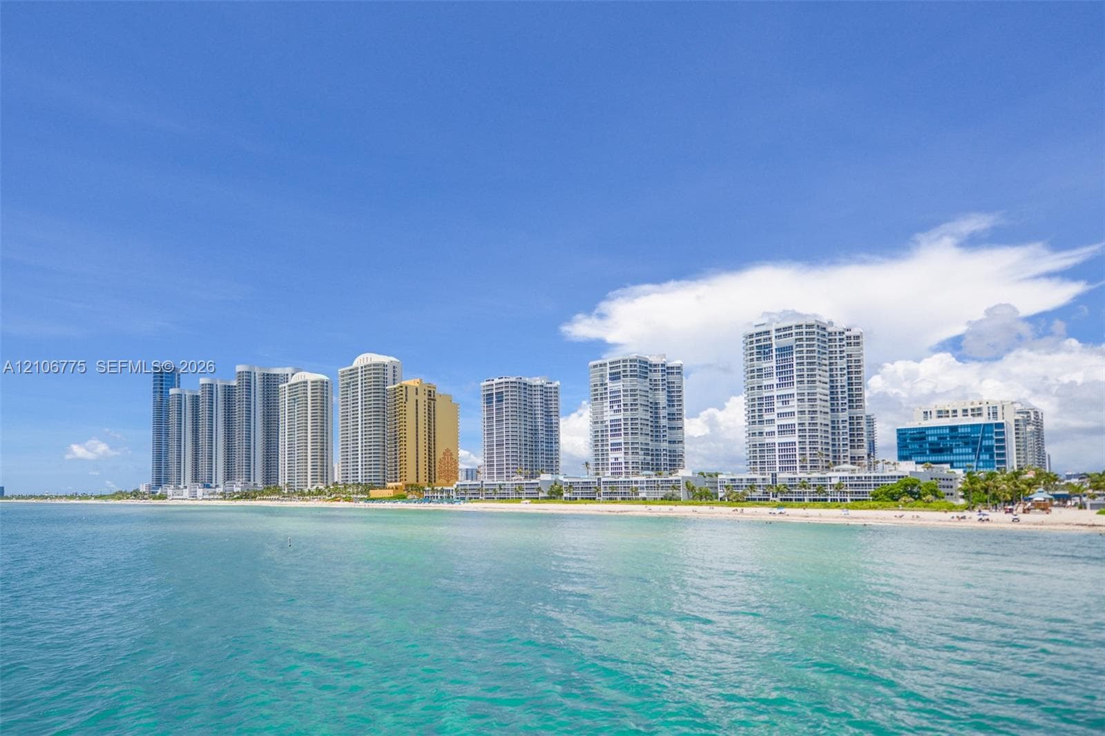 Direct oceanfront location featuring sandy coastline and proximity to high-rise metropolitan structures
