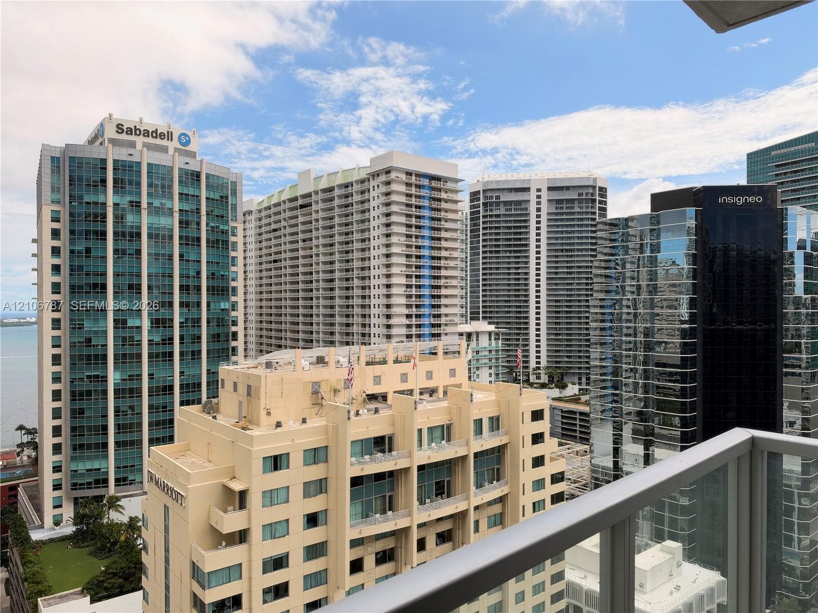 Exterior balcony featuring a glass and metal railing overlooking a cityscape