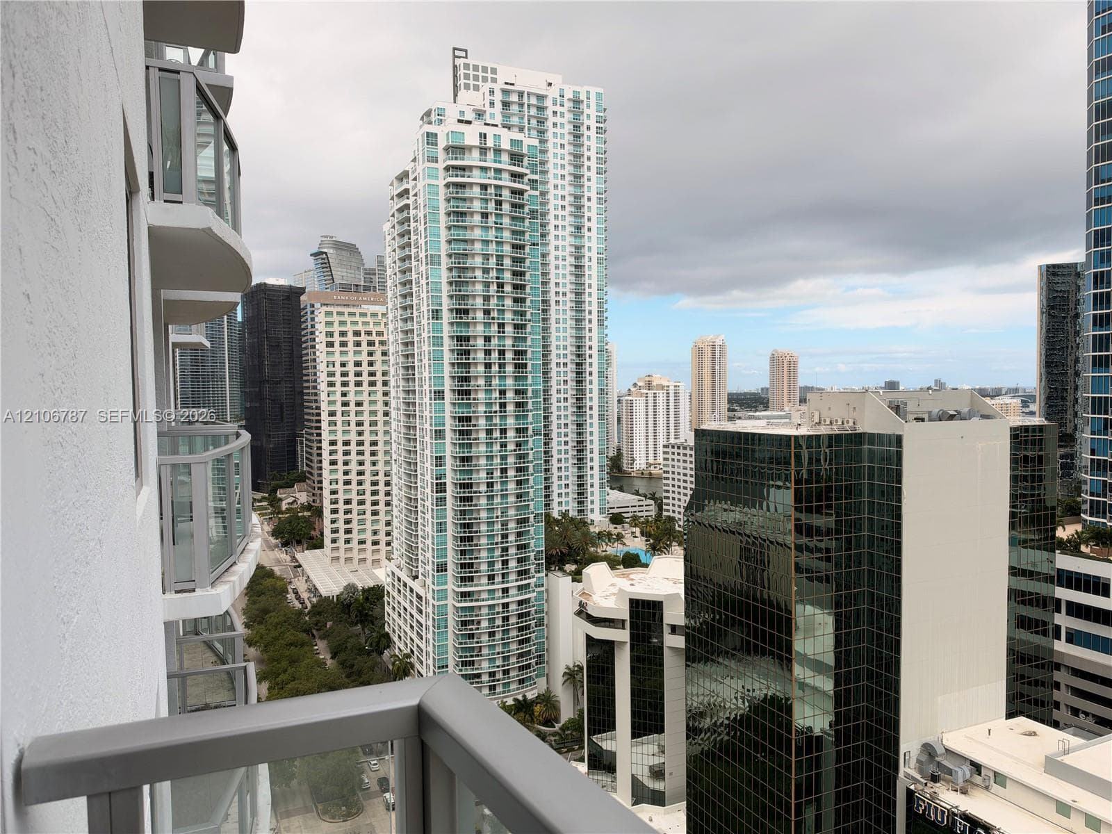 Private balcony with glass panel railing offering a metropolitan cityscape