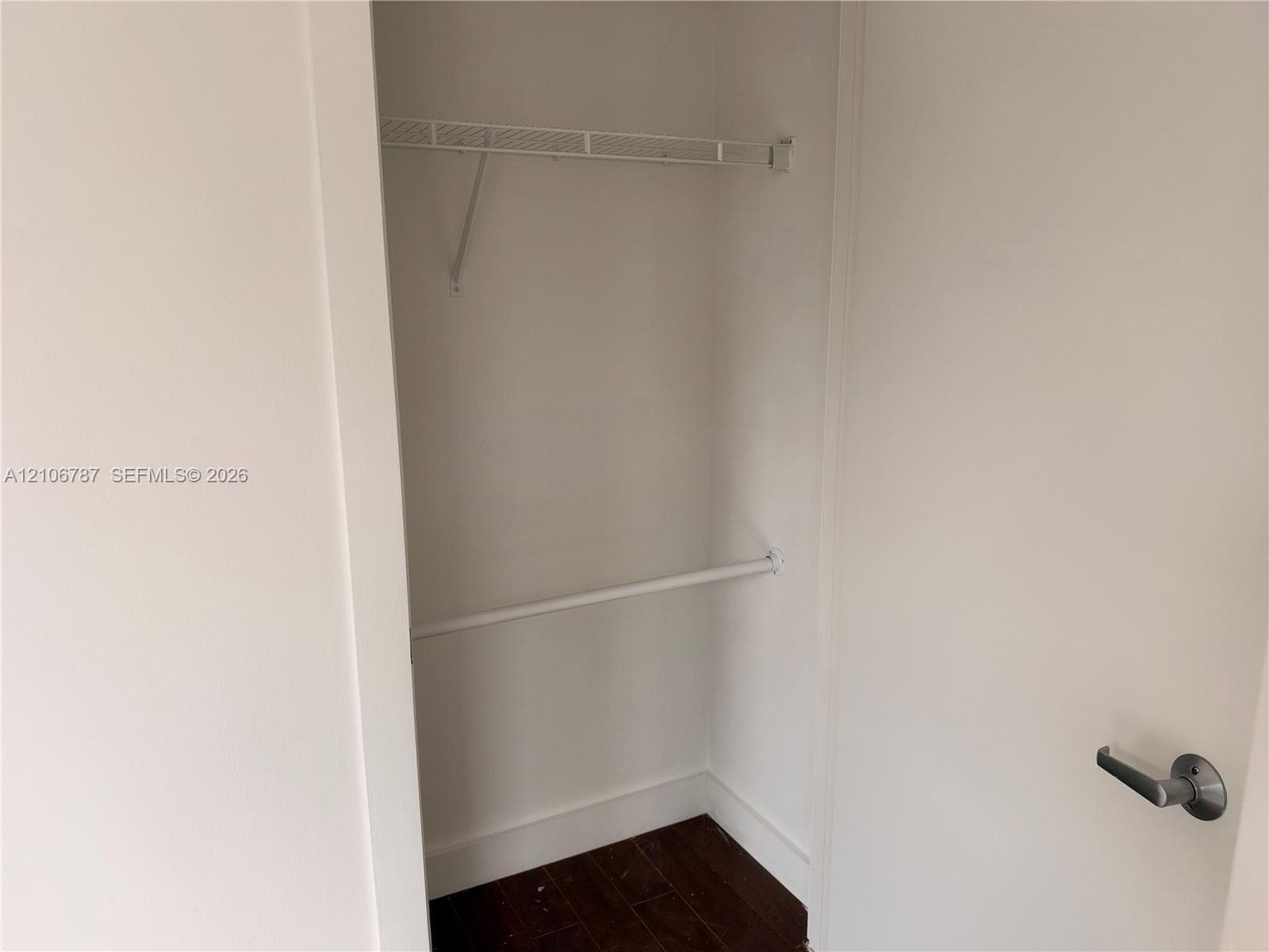 Closet featuring white interior walls, wood-finish flooring, and a built-in wire shelf with an integrated hanging rod
