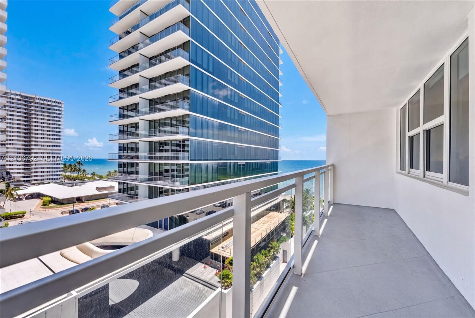 Private balcony featuring a glass-panel railing, concrete flooring, and large-format exterior windows