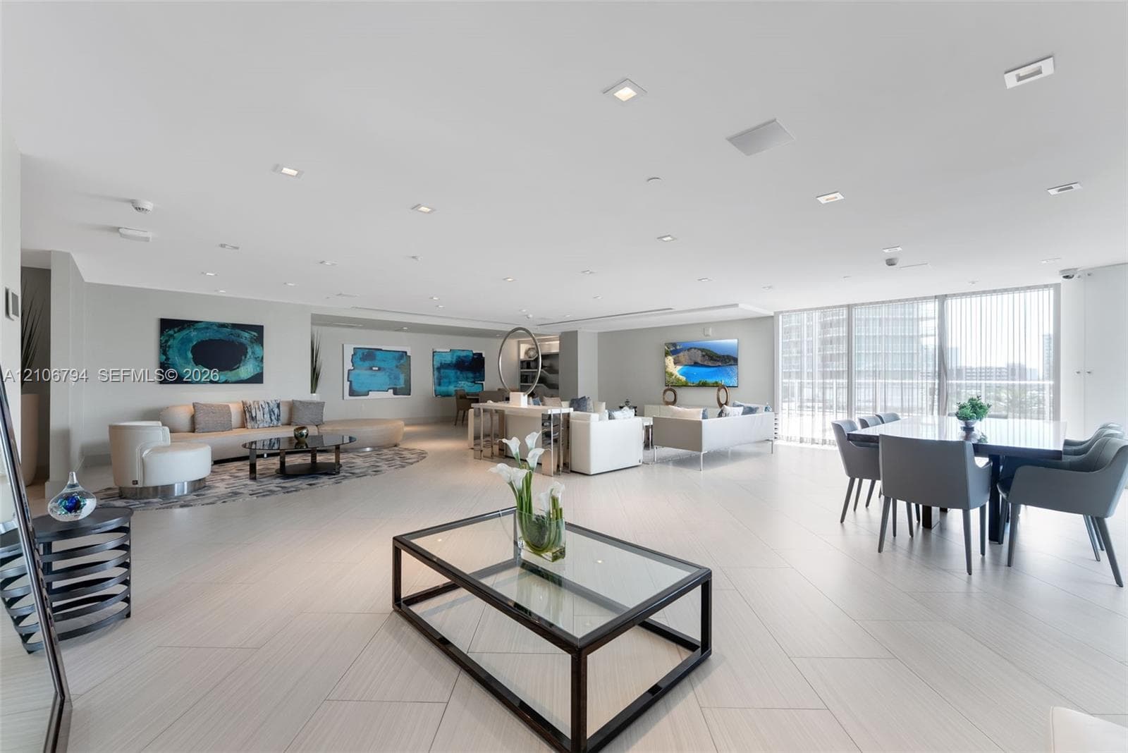 Open-concept floor plan featuring large-format tile flooring, recessed lighting, and floor-to-ceiling windows