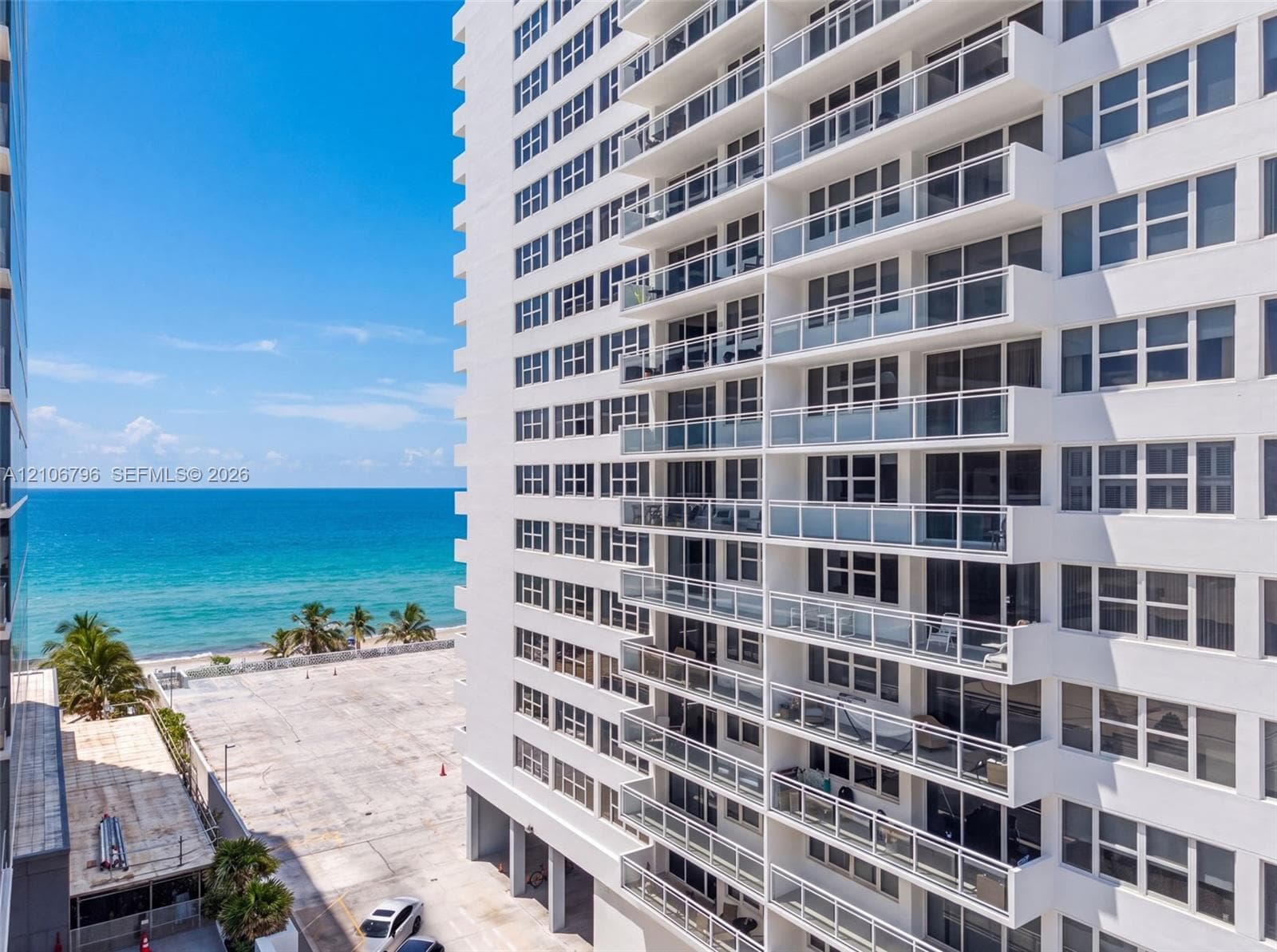High-rise exterior featuring private balconies with glass railings and direct oceanfront exposure
