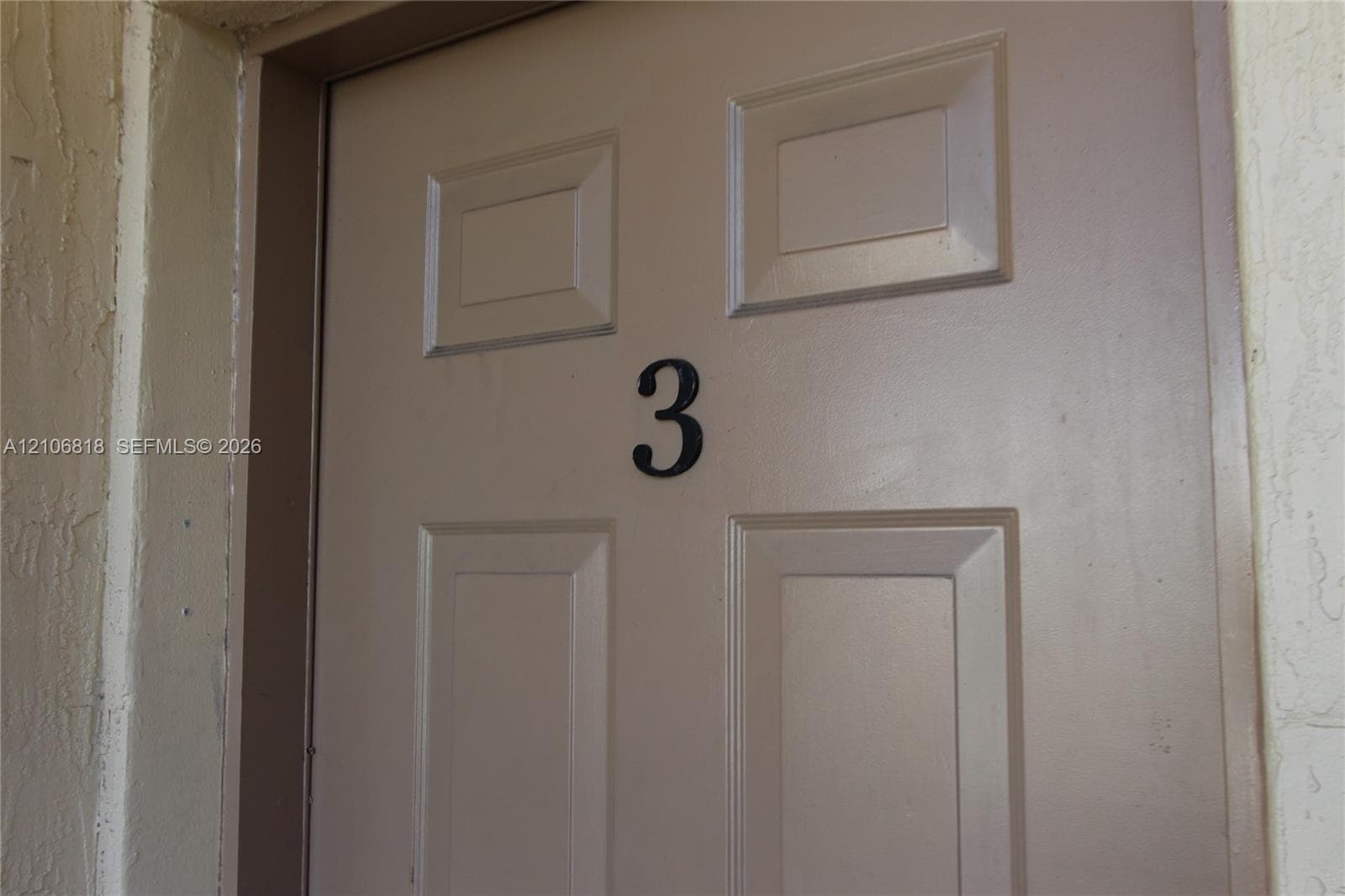 Four-panel entry door featuring a matte finish and a central numeral identifier