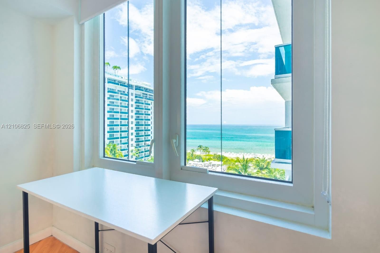 Floor-to-ceiling double-pane windows, wood-finish flooring, and coastal scenery